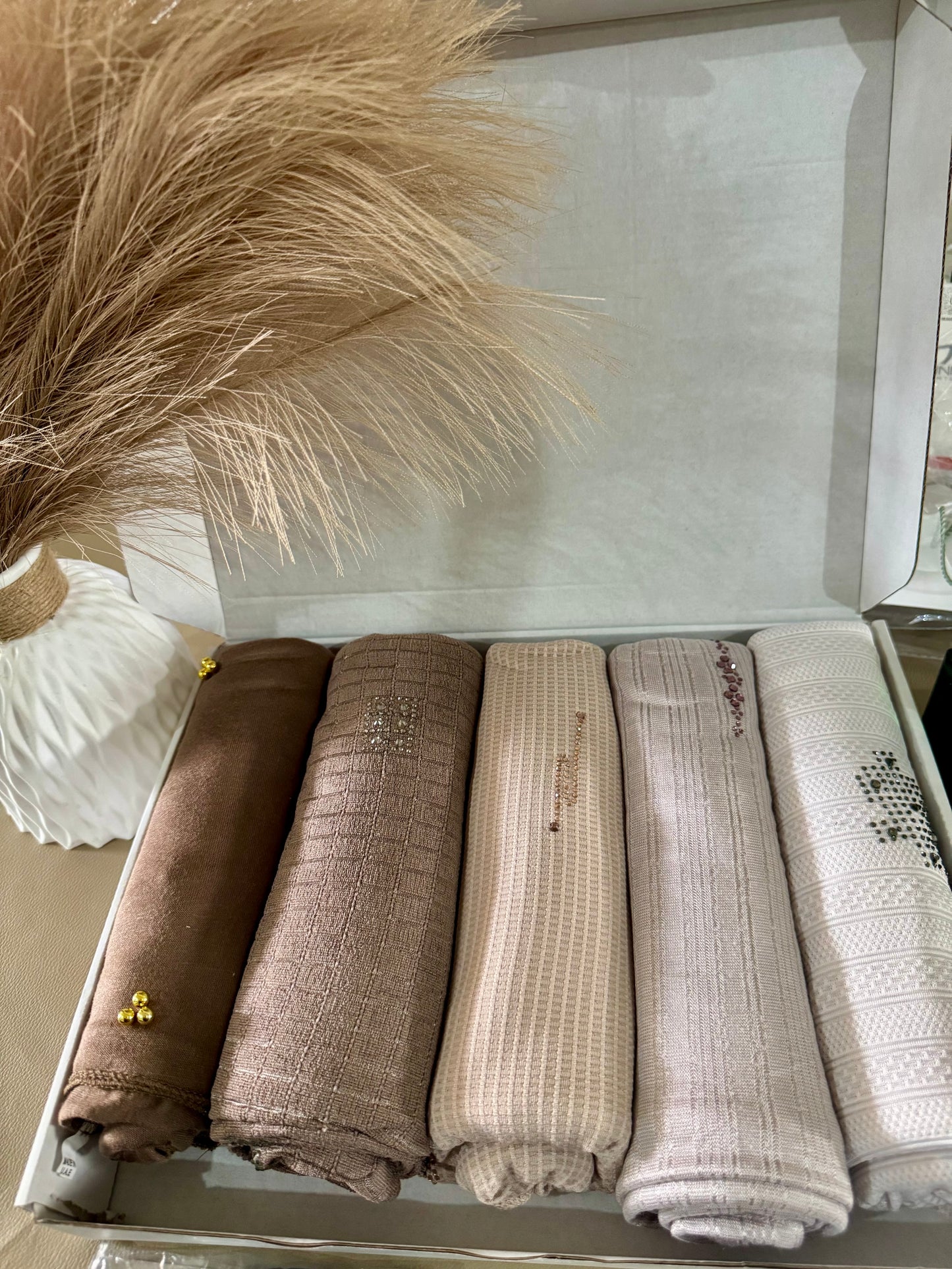 “Five cotton hijabs in gentle, natural shades, neatly packed in a gift box.”